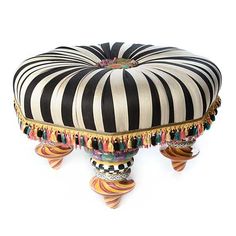 a black and white striped ottoman with tassels