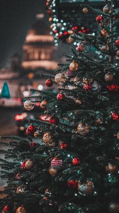 a christmas tree with ornaments and lights in the background