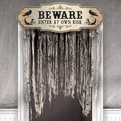 a sign that says beware enter at own risk hanging from the side of a door