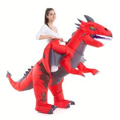 a woman riding on the back of a inflatable dinosaur costume with an angry look