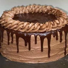 a chocolate cake covered in icing and drizzled with chocolate on top