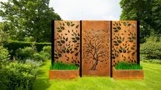 a metal screen with trees and grass in the center, on top of a green lawn