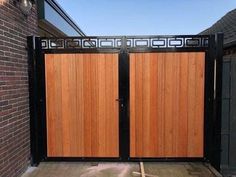 a wooden gate in front of a brick building