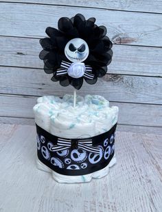 a diaper cake decorated to look like jack skellingy with a flower on top