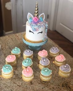 cupcakes with frosting and an unicorn's head on top are sitting next to each other