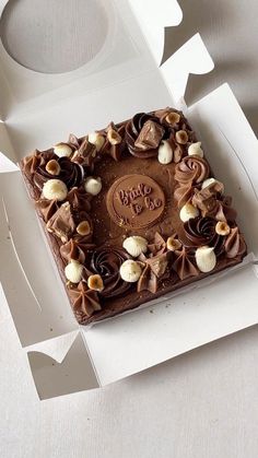 a square cake with chocolate frosting and marshmallows in the shape of a happy birthday