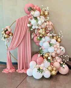 a balloon arch with balloons and flowers on it