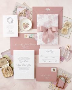 the wedding stationery is laid out on top of each other, including cards and envelopes