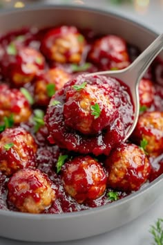 cranberry meatballs in a pan with a spoon