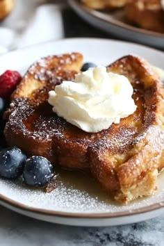 french toast with whipped cream and blueberries on a plate next to other desserts