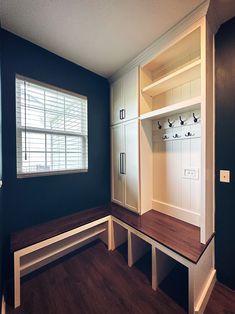 an empty room with wooden flooring and built - in shelves, along with two benches