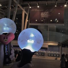 two people holding up lights in front of a building