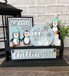 two penguins are standing next to a sign that says come christmas with us have an ice day