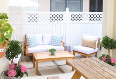 an outdoor living area with couches, tables and potted plants on the patio