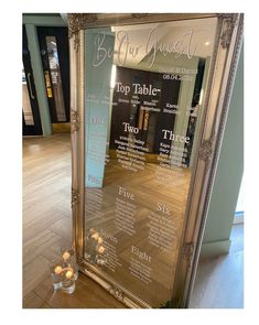 a large silver framed mirror sitting on top of a wooden floor