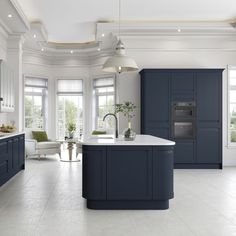 a large kitchen with blue cabinets and white counter tops, along with an island in the middle