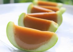 four slices of melon sitting on top of a white plate