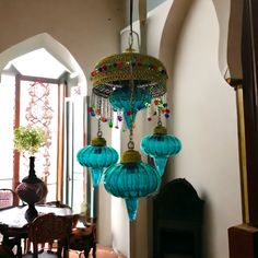 a blue chandelier hanging from the ceiling in a room with tables and chairs