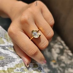 a woman's hand with a diamond ring on top of her finger and the other hand holding an object