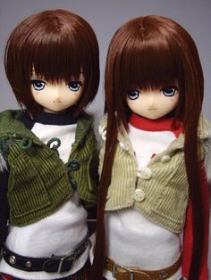 two dolls standing next to each other wearing sweaters and vests with long hair