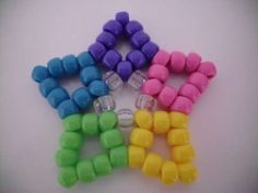 five different colored candy candies arranged in the shape of an x on a white surface