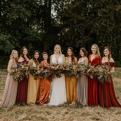 a group of women standing next to each other holding bouquets in front of them