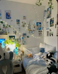 a bedroom with white walls and lots of pictures on the wall