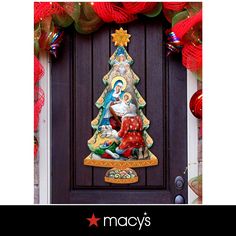 a christmas tree decoration on the front door of a house with red and green decorations around it