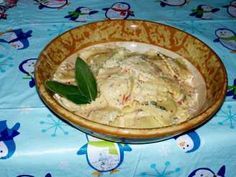 a wooden bowl filled with food sitting on top of a blue tablecloth covered table