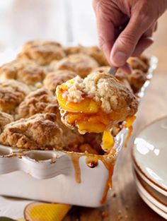 a person is taking a bite out of a peach cobbler