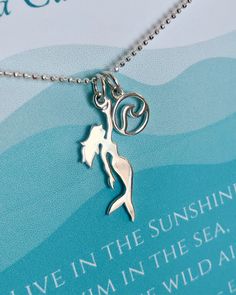 Mermaid Necklace With Emerson Quote | The Life Divine Our Sterling Silver Mermaid Necklace is presented on a on a shimmering diamond cut ball chain and beautifully carded- ready for gift giving!The Gift Card Features the Emerson quote, "LIVE IN THE SUNSHINE, SWIM IN THE SEA, DRINK THE WILD AIR."Select from 3 Sterling Silver Chain Lengths-16”, 18” or 20”You have the option of adding our Wave charm to the Mermaid necklace.Our Sterling Silver Mermaid charm measures 1 1/8 " H (including jump ring) x