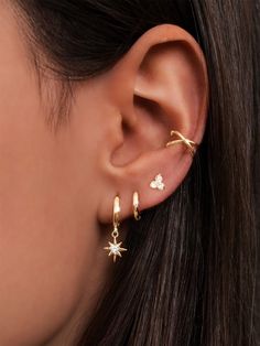 a close up of a person's ear with two small stars attached to it