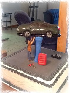 a cake shaped like a car with a man standing next to it