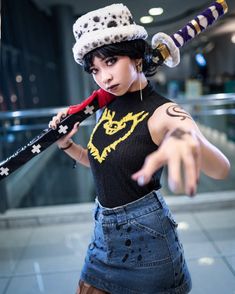 a woman wearing a hat and holding a baseball bat in one hand while pointing at the camera