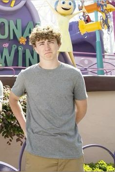 a young man standing in front of a sign