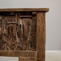 an old wooden cabinet with many tools attached to it's sides and handles on each side