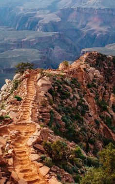 the path to the top of the mountain is made of stone and has many steps leading up it