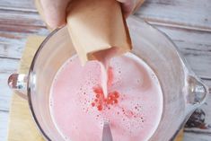 a person is pouring liquid into a blender