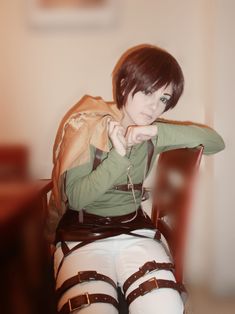 a woman sitting on top of a chair wearing white pants and knee high boots with straps around her ankles