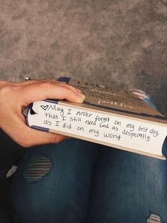 a person holding a book with writing on it