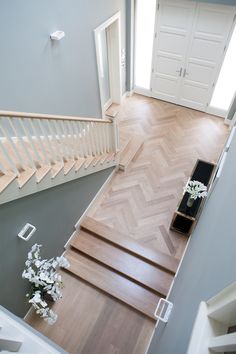 an overhead view of a staircase with flowers on the floor and white doors in the background