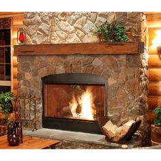 a stone fireplace in a living room with wood logs and potted plants on the mantle