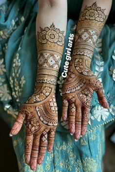 two hands with henna tattoos on them