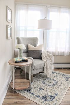 a living room with a chair, rug and lamp in it's corner area