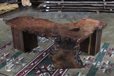 a wooden bench sitting on top of a rug next to stacks of wood planks