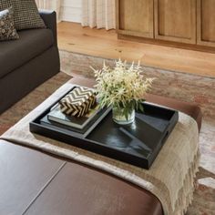 a living room with a couch, ottoman and coffee table in the middle of it