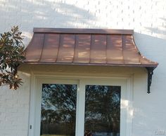 a white door with a brown roof and window sill