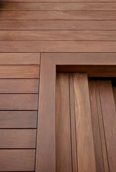 a clock on the side of a wooden building with wood slatted flooring