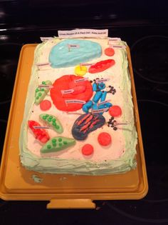 a cake with white frosting and colorful decorations on it's side sitting on a tray