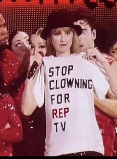 a woman holding up a t - shirt with the words stop clowning for rep tv on it